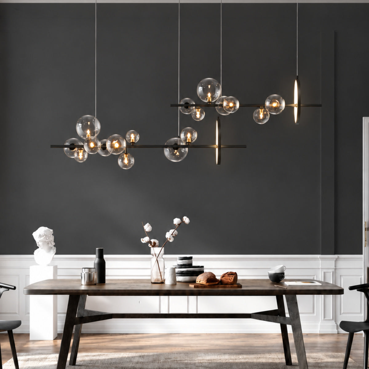 Gold-toned bulbs hanging over a dining table in a contemporary dark gray and black dining room.