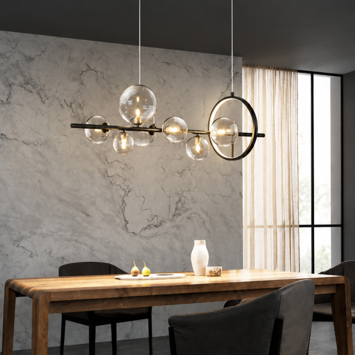 Modern multi-light cluster pendant chandelier with clear glass globes and warm gold-toned bulbs hanging over a dining table in a contemporary dark gray and black dining room.