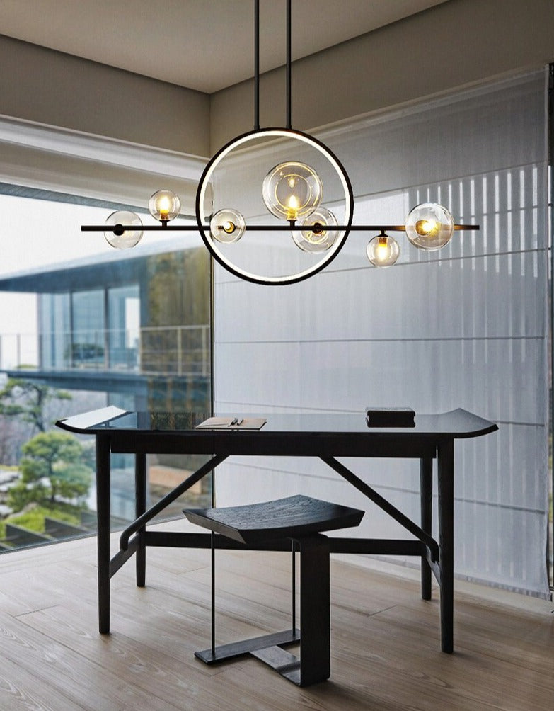 Modern pendant light with glass globes and a circular LED ring above a table by the window.